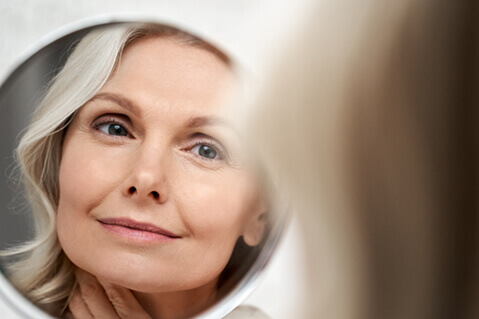 Beautiful woman looking in mirror